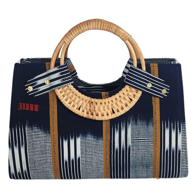 Introducing the Nasika Mudcloth Tote, a stunning handbag crafted from rich mudcloth. This traditional Malian fabric is renowned for its unique texture and cultural significance, making each bag a wearable piece of art. The intricate patterns and earthy tones of the mudcloth create a sophisticated look that's both elegant and eye-catching. With its spacious interior, sturdy cane handles, and inner pocket, this bag is as functional as it is beautiful. Every purchase supports women from low-income Accra Ghana, Cane Handles, Low Income, Tote Handbag, Mud Cloth, Cultural Heritage, Women Supporting Women, Intricate Patterns, Earthy Tones