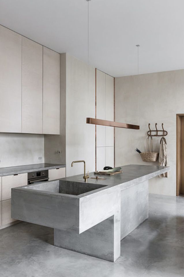 a kitchen that has a sink in the middle of it and some hanging items on the wall