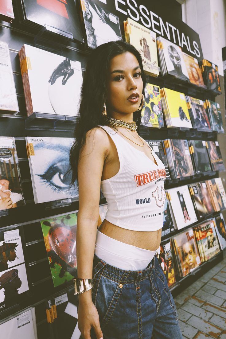 a woman standing in front of a wall full of cds