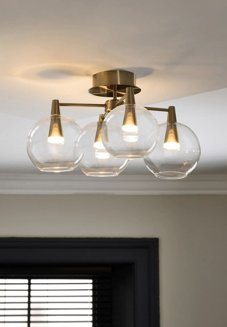 three clear globe lights hang from the ceiling