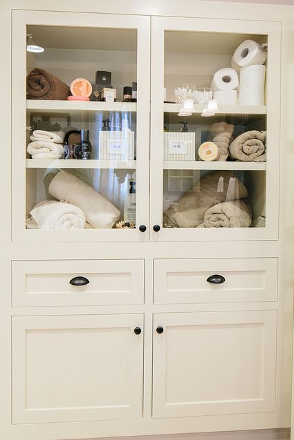 a white cabinet filled with lots of towels