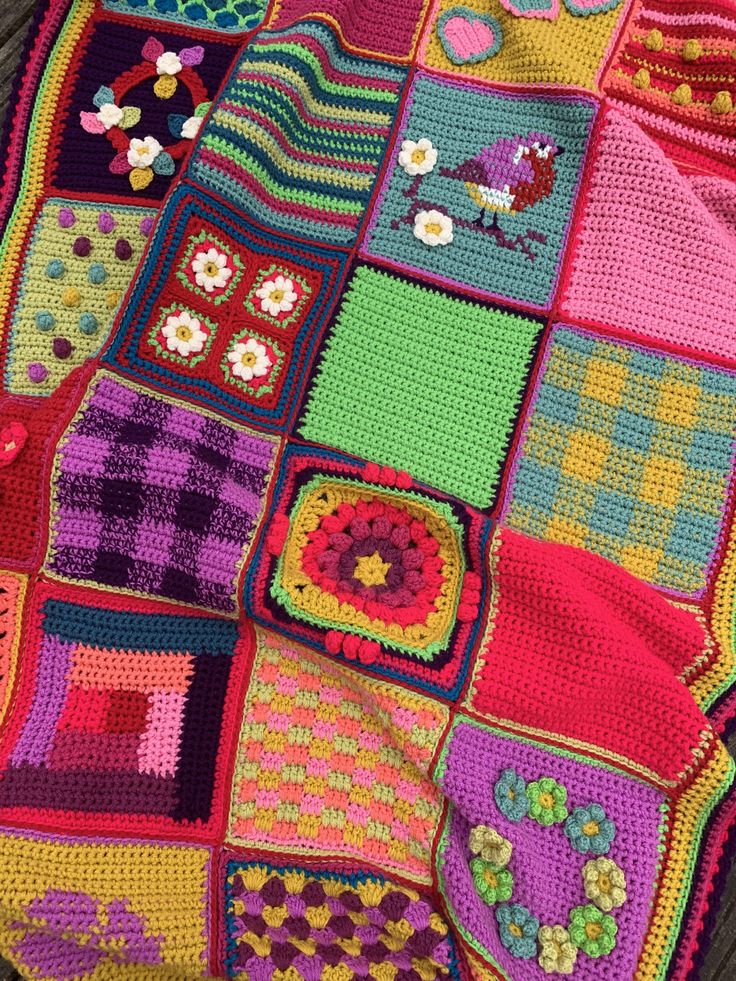 a colorful crocheted blanket is laying on the floor