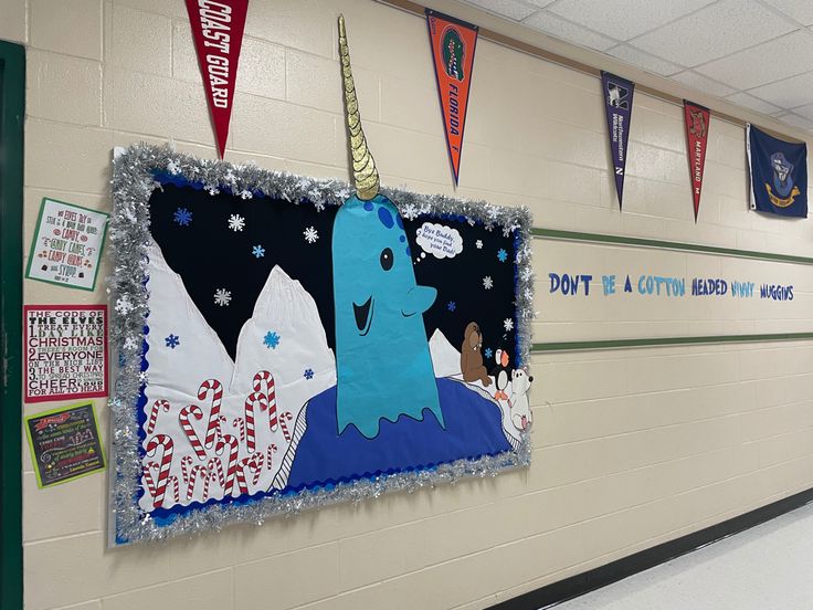 a bulletin board with an unicorn on it in a school hallway decorated for the holiday season