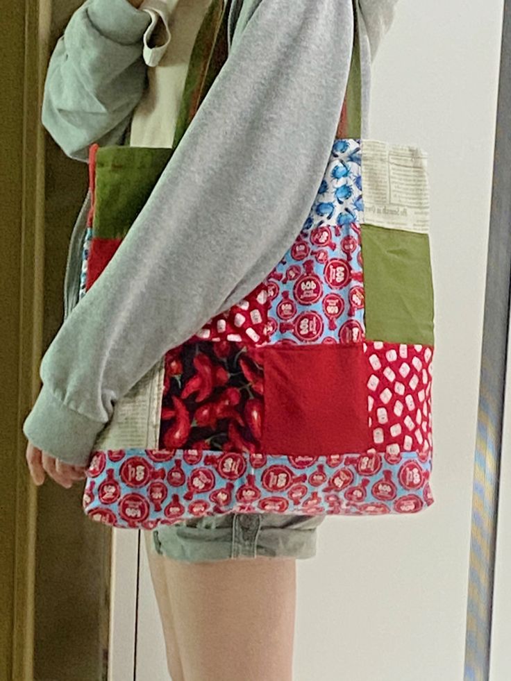 a woman is holding a multicolored patchwork purse and talking on the phone