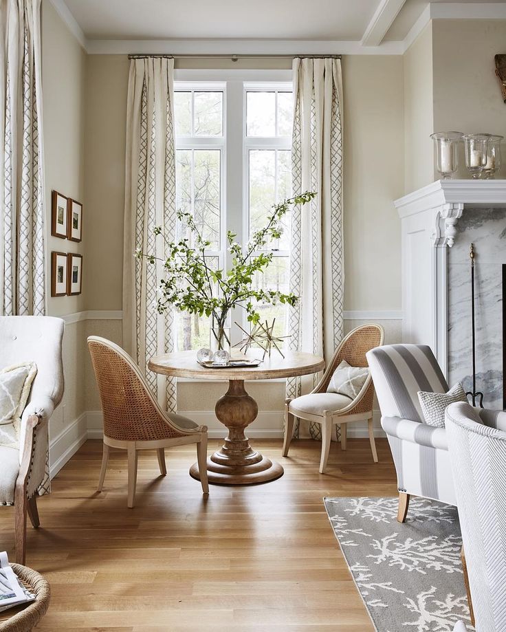 a living room filled with furniture and a fire place in front of a large window