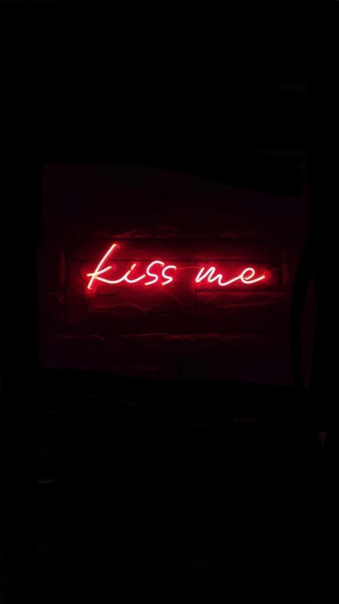 a red neon sign that says kiss me