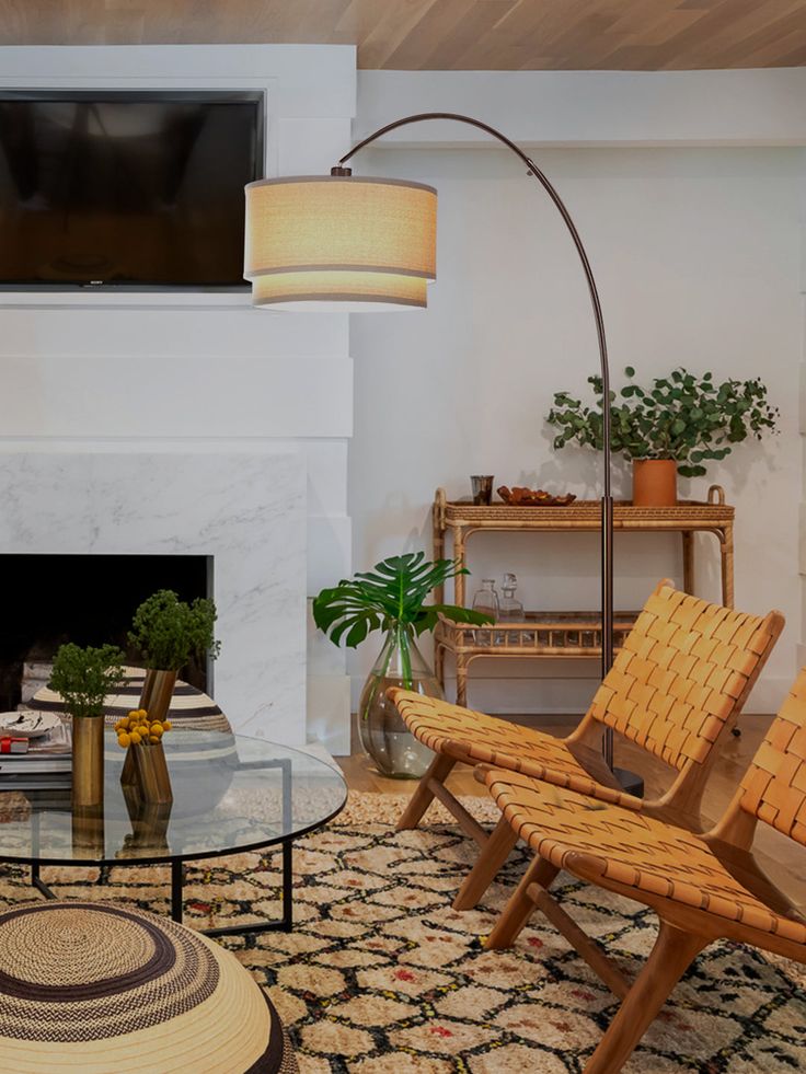 a living room filled with furniture and a flat screen tv mounted on the wall above a fireplace