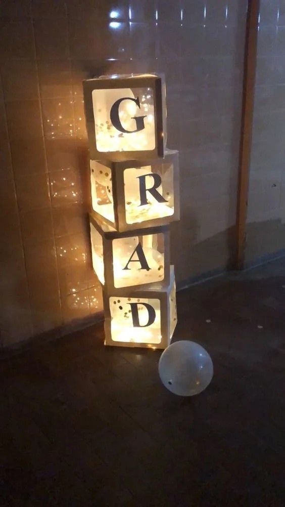 some lights that are sitting on the ground in front of a wall with words spelled out