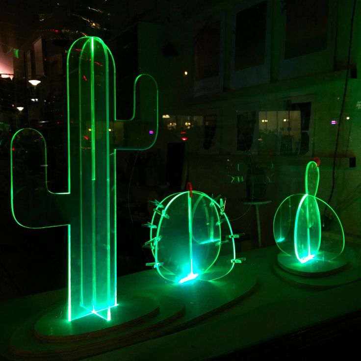 three lit up cactus sculptures sitting on top of a table