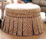 a dog sitting on the floor next to a chair and ottoman with a zebra print cover