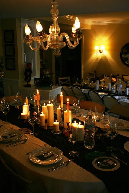 a dining room table is set with candles and plates