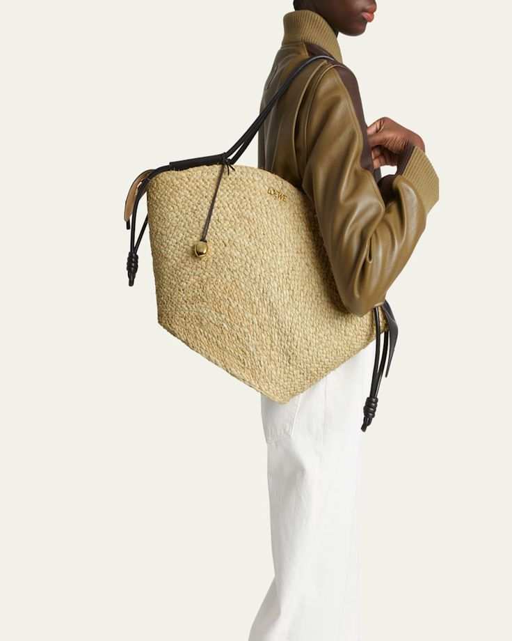 Loewe "Paseo" basket tote bag in raffia and leather     Rolled shoulder straps with Anagram pebble accent     Zip top closure     Interior, one slip pocket     Approx. 12.5"H x 22.6"W x 5.5"D    Made in Spain Designer Everyday Straw Tote Bag, Designer Straw Tote Bag For Everyday, Designer Double Handle Straw Bag For Everyday, Designer Natural Bucket Bag With Braided Handles, Designer Straw Tote Shoulder Bag, Designer Straw Shoulder Bag With Leather Handles, Designer Bucket Bag With Leather Handles In Natural, Designer Natural Bucket Bag With Leather Handles, Designer Straw Bag With Braided Handles For Everyday