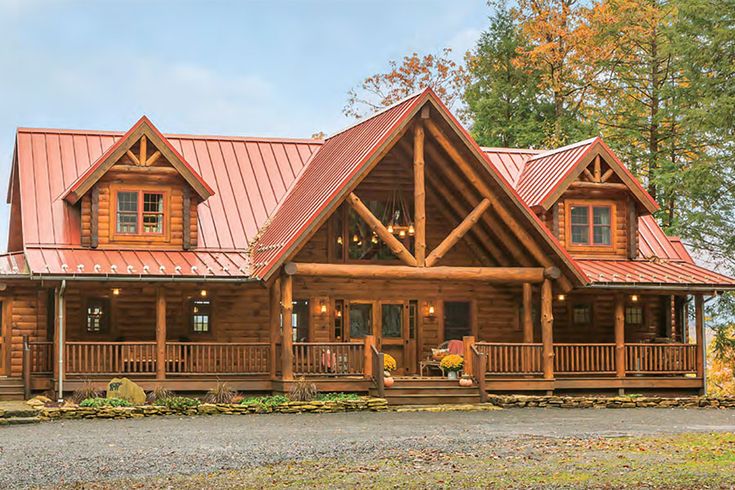 a large log home with red tin roof