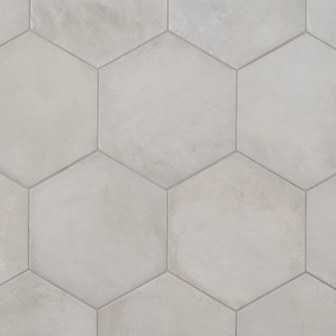 a white tile wall with hexagonal tiles on it