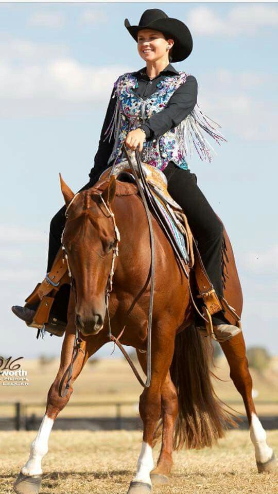 a woman riding on the back of a brown horse wearing a cowboy hat and boots