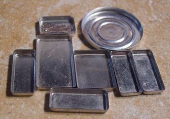 several pieces of metal sitting on top of a table next to a silver canister