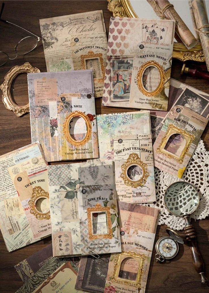 many different pieces of paper on top of a wooden table next to an ornate mirror