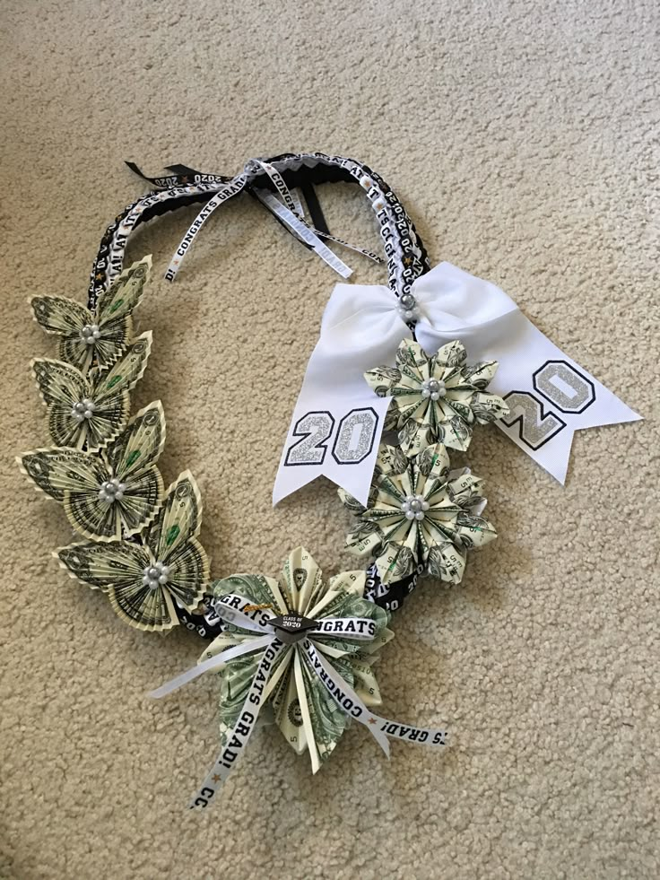 a wreath made out of dollar bills on the floor with ribbons around it and numbers