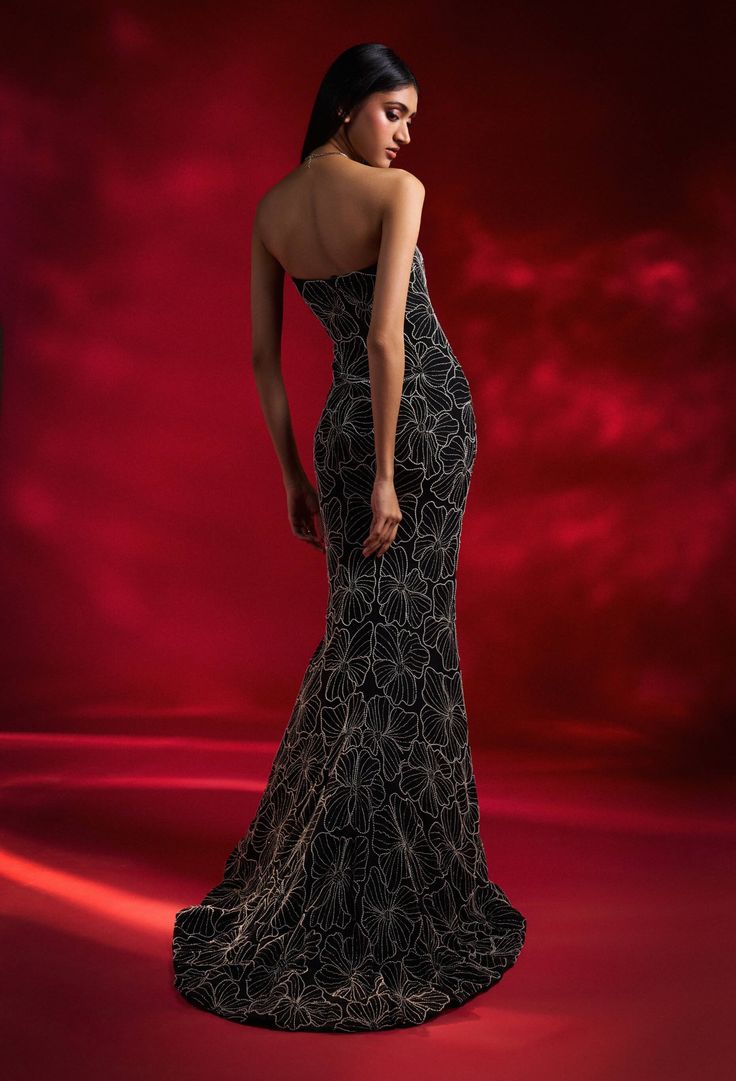 A black tube gown dazzles with striking floral embroidery and a flowing trail, creating a show-stopping look that combines sophistication with bold style. Tube Gown, Gown For Women, Gown Pattern, Black Tube, Embellished Gown, Beaded Neckline, Ladies Gown, Contemporary Fashion, Bold Fashion