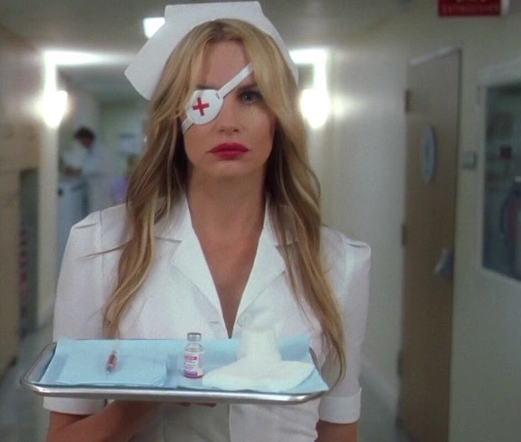 a woman in a nurse outfit holding a tray with a cake on top of it