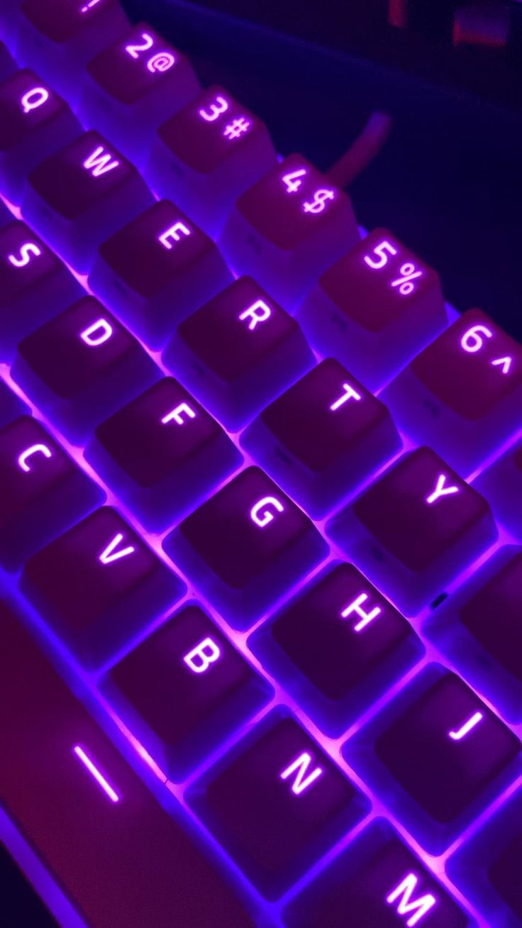 a close up view of a keyboard with purple light on it's keys and numbers