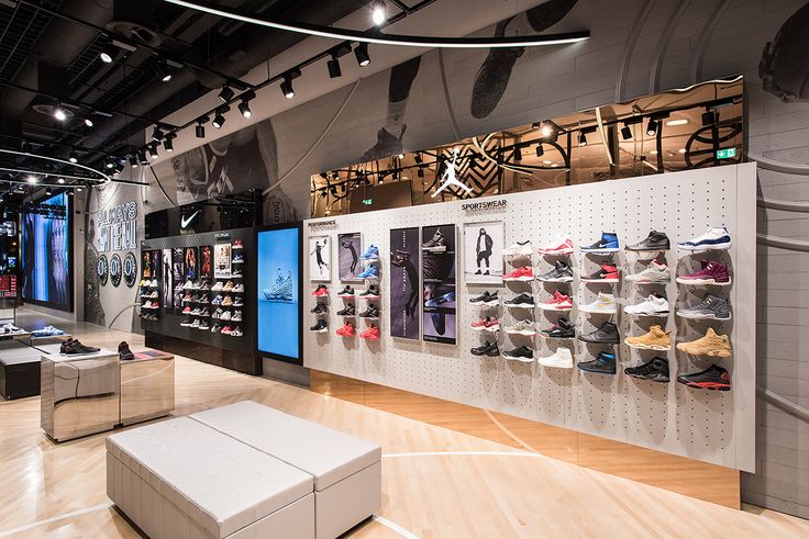 the inside of a shoe store with lots of shoes hanging on the walls and shelves