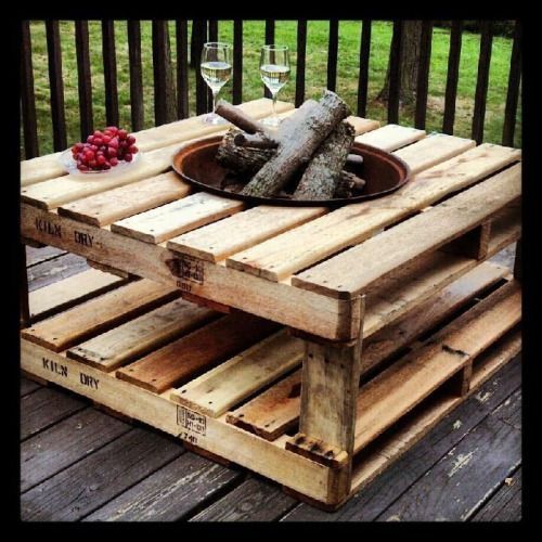 a table made out of wooden pallets with wine glasses and grapes on the side