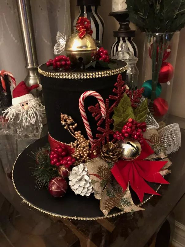 a black hat decorated with candy canes and christmas decorations on top of a table