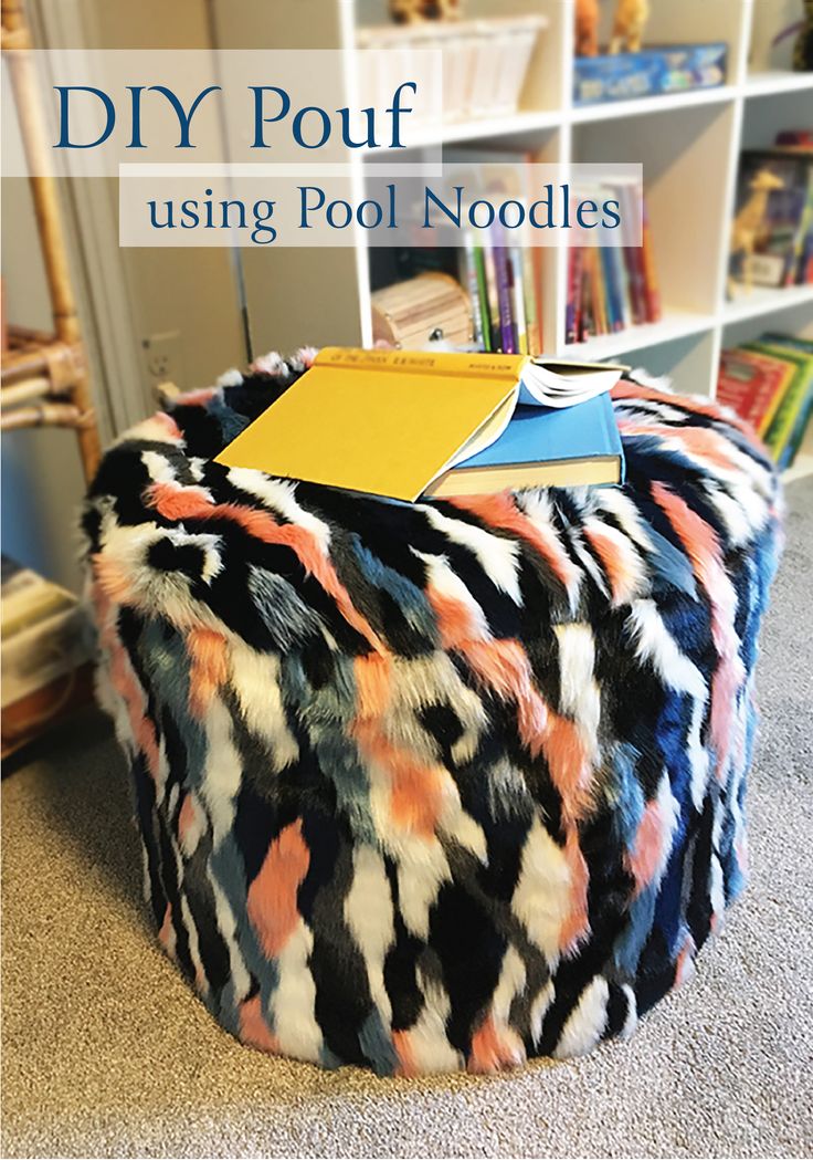 a colorful pouf sitting on top of a floor next to a book shelf filled with books