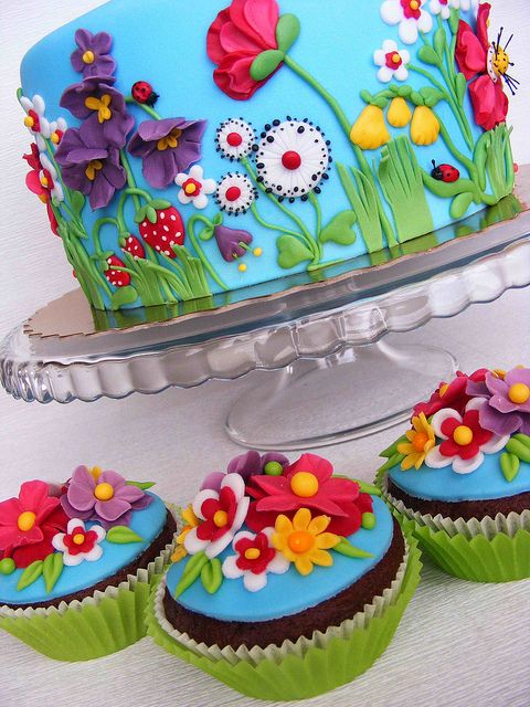 the cake is decorated with flowers and butterflies