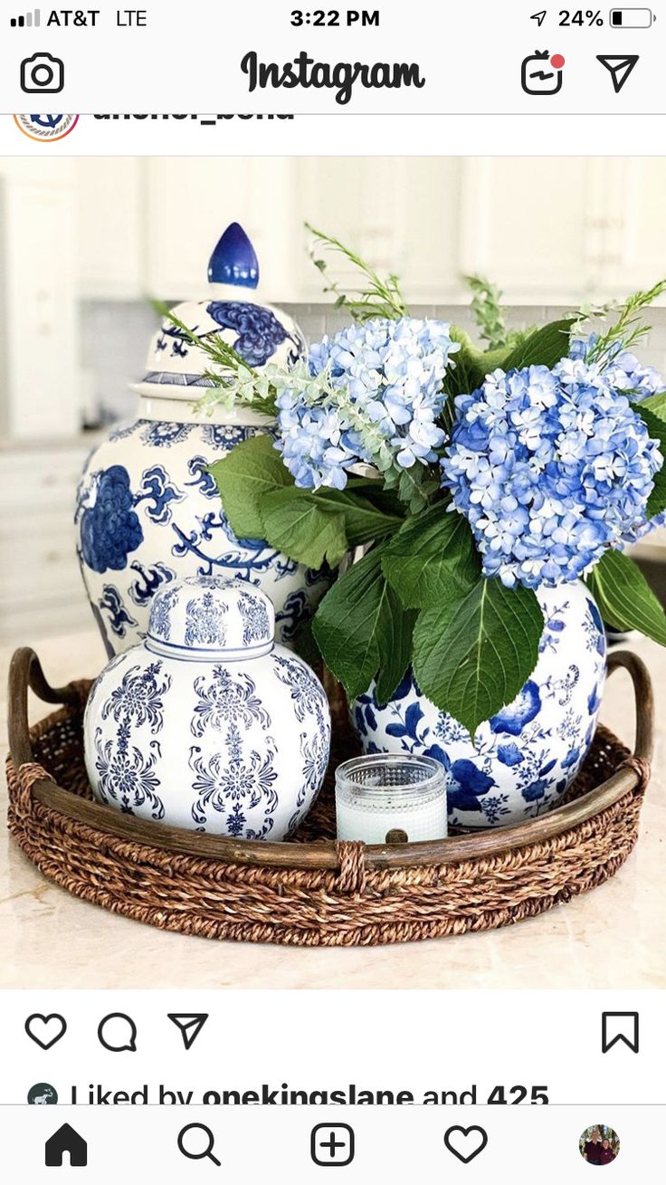 blue and white vases sitting on top of a wooden tray with flowers in them