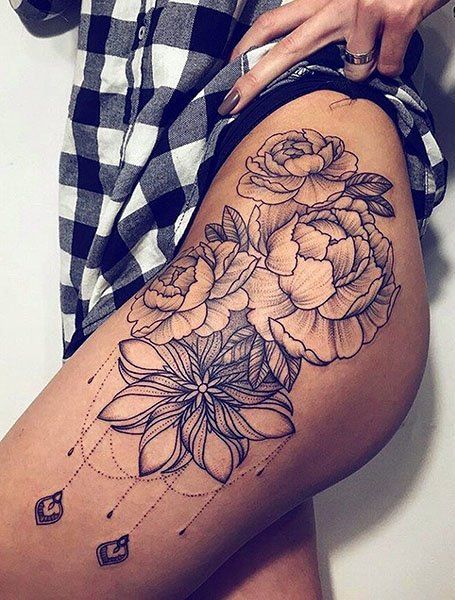 a woman is showing off her thigh with flowers on the side and in the middle