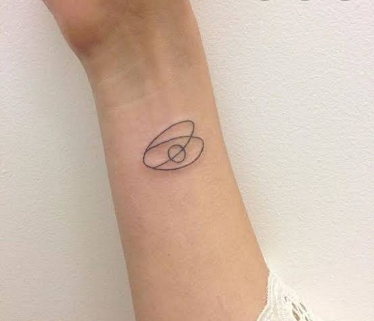 a woman's wrist with a small tattoo on the left side of her arm