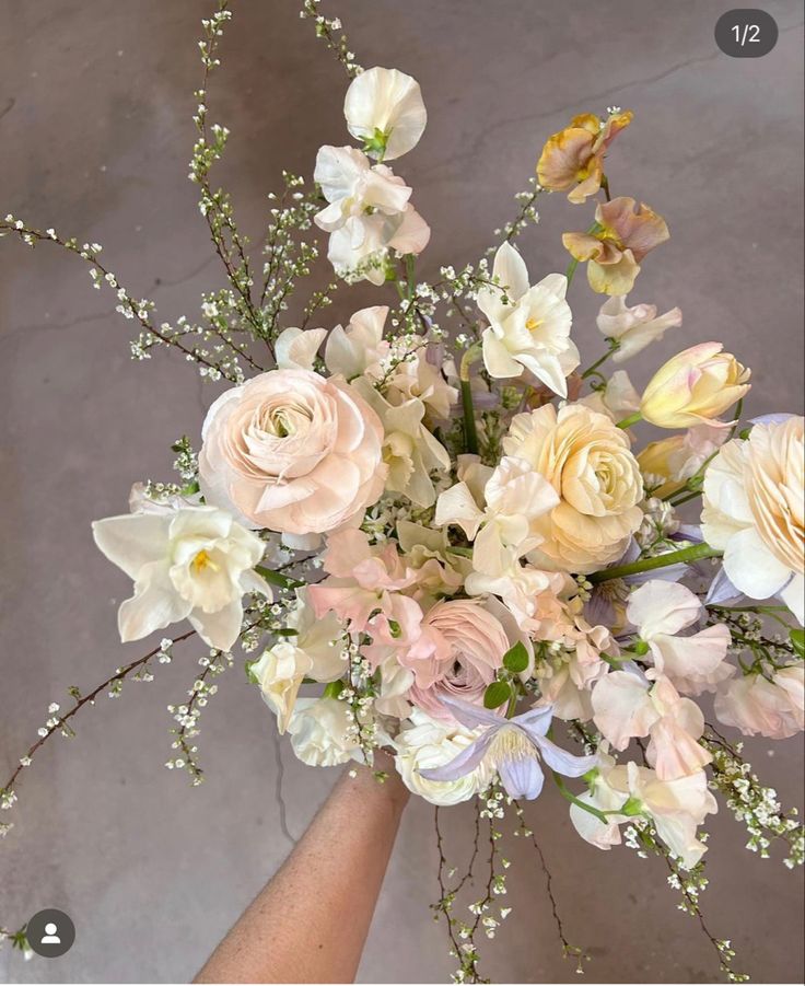 a vase filled with lots of white and pink flowers