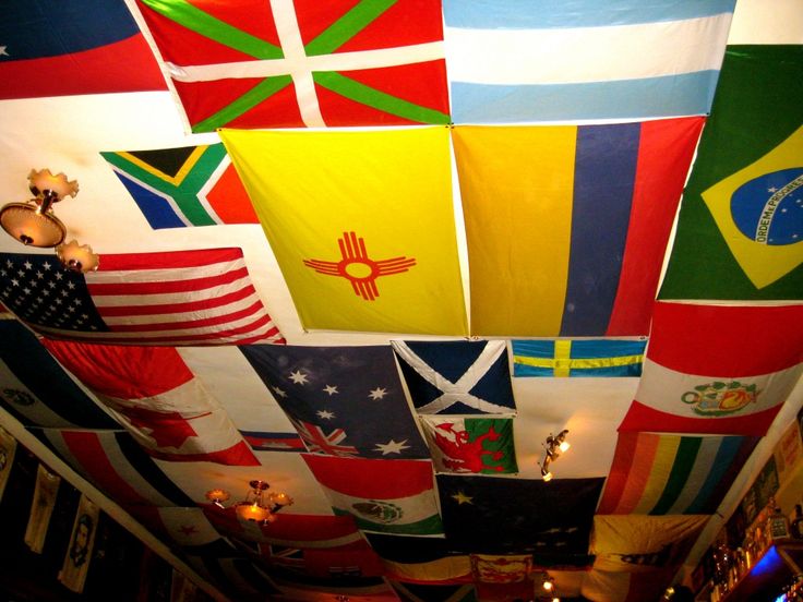 many different flags are hanging from the ceiling