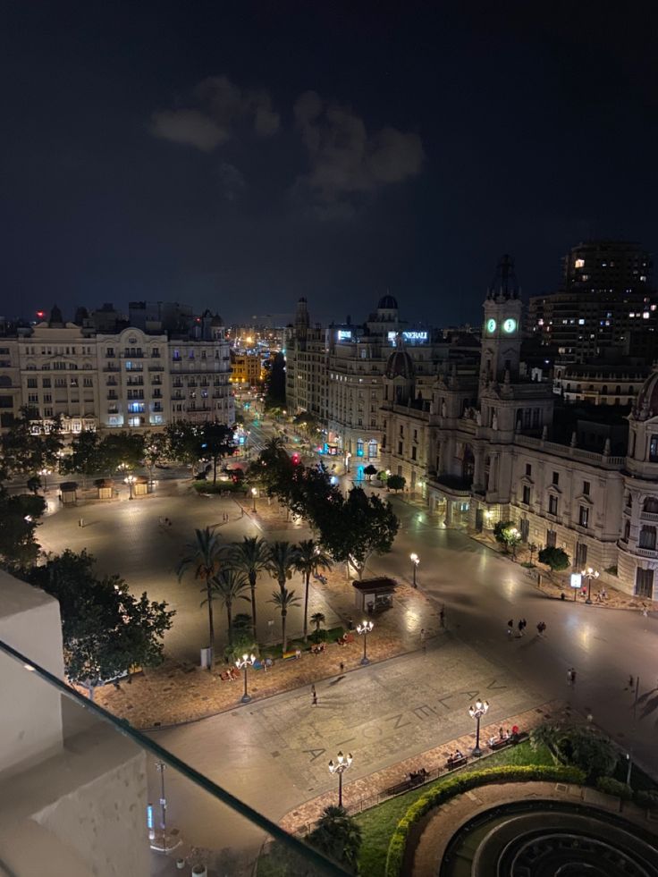 an aerial view of a city at night with buildings and street lights in the foreground