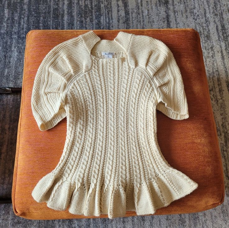 a white sweater sitting on top of a wooden tray