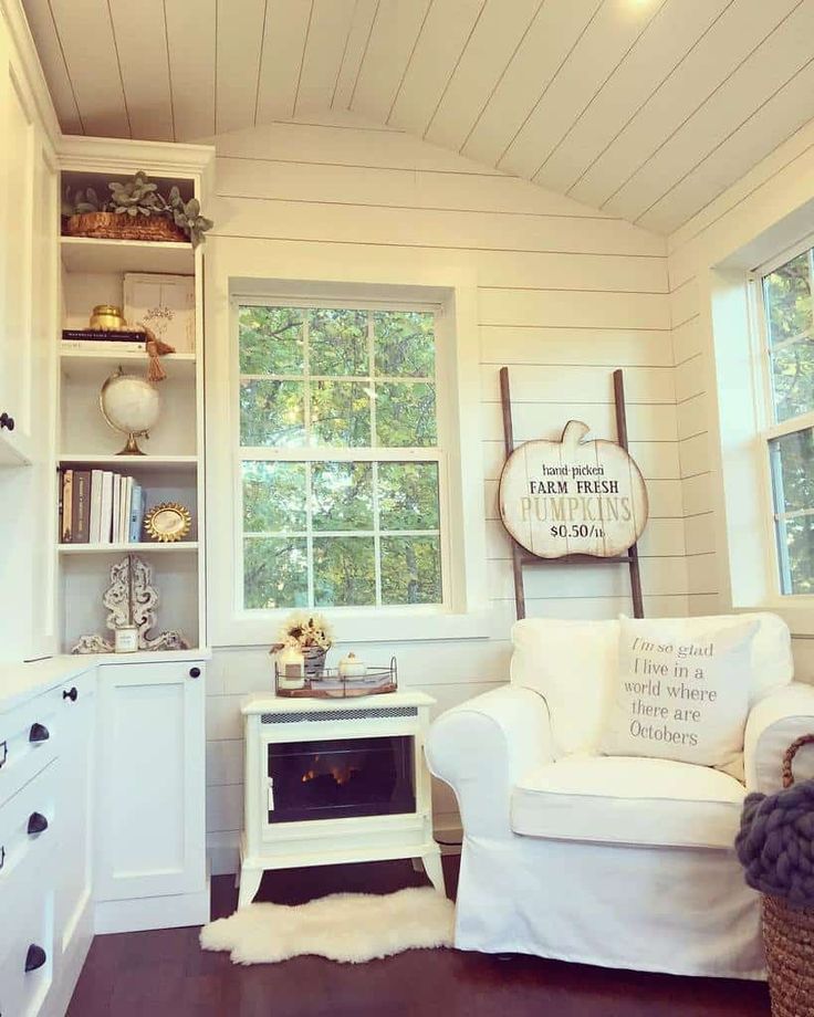 a living room filled with furniture next to a window and book shelf on top of a hard wood floor