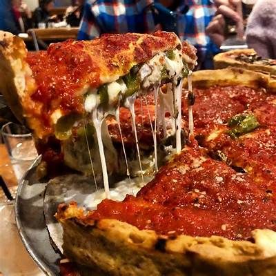 a deep dish pizza is being lifted from the pan