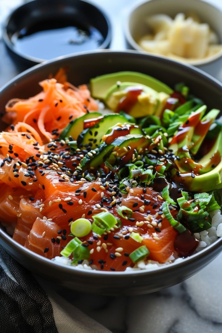 a bowl filled with sushi, avocado and other foods on top of a table