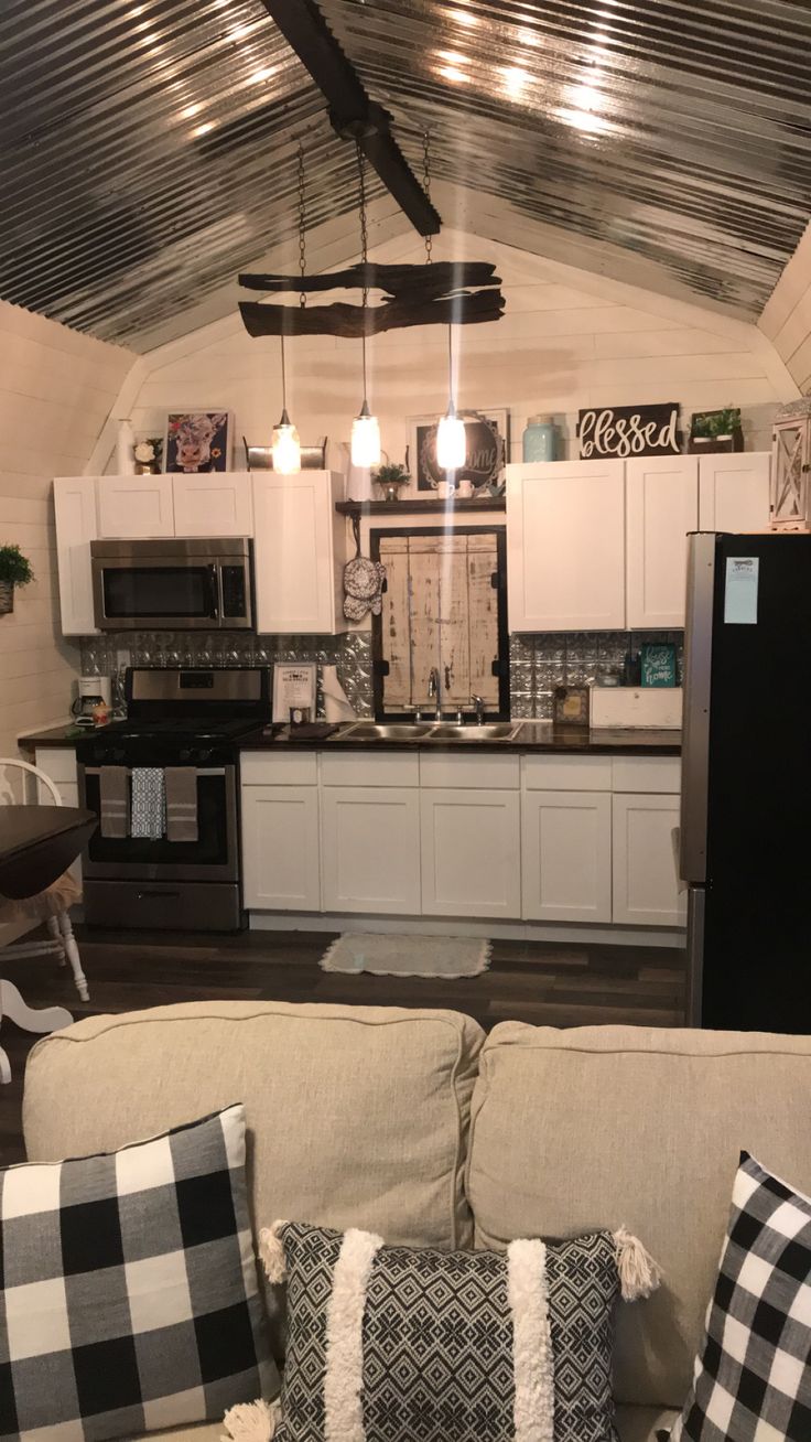 a living room filled with furniture next to a kitchen