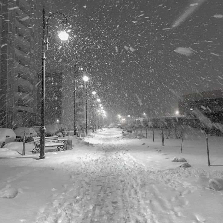 a snowy street at night with lots of snow on the ground