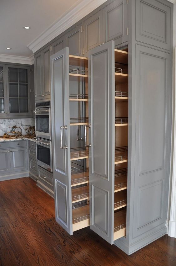 a kitchen with gray cabinets and wood floors