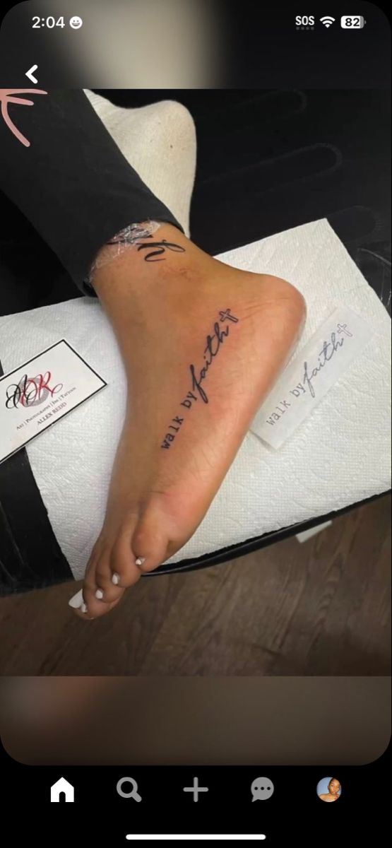 a person with a tattoo on their foot is sitting on a towel and has her name written on it