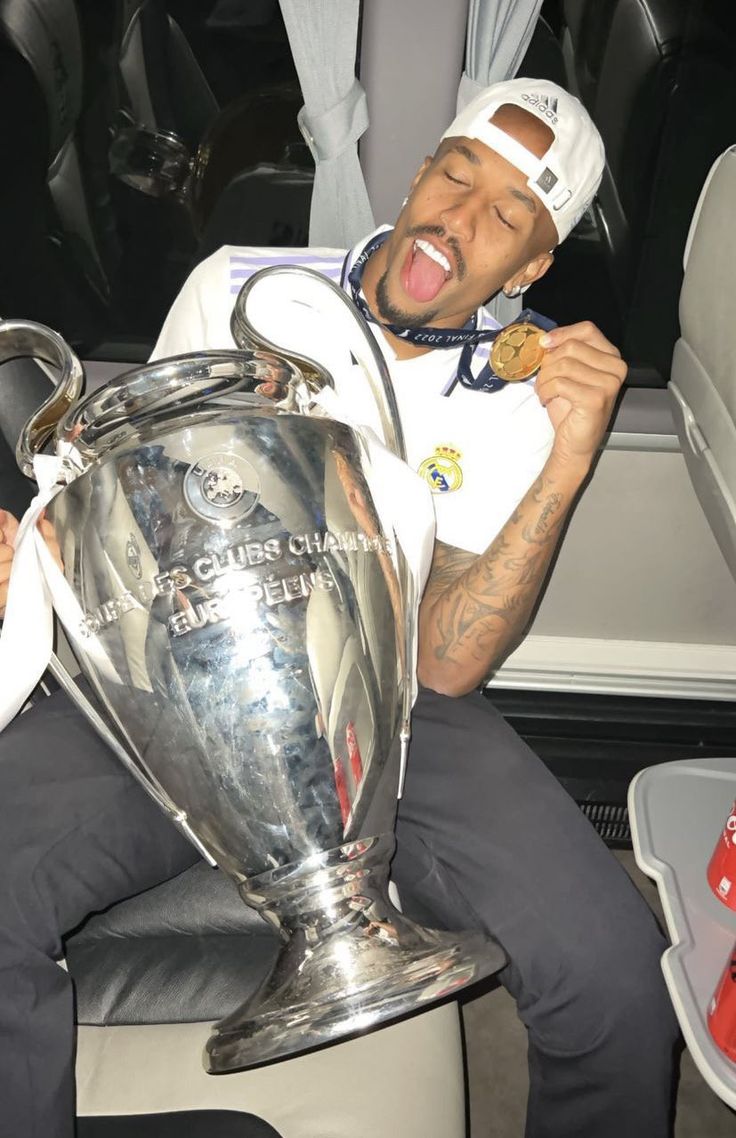 a man sitting on top of a chair with a trophy in his hand and laughing