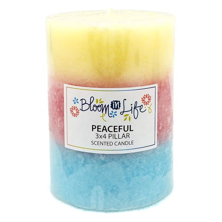 a candle that has been colored in different colors and is sitting on a white surface