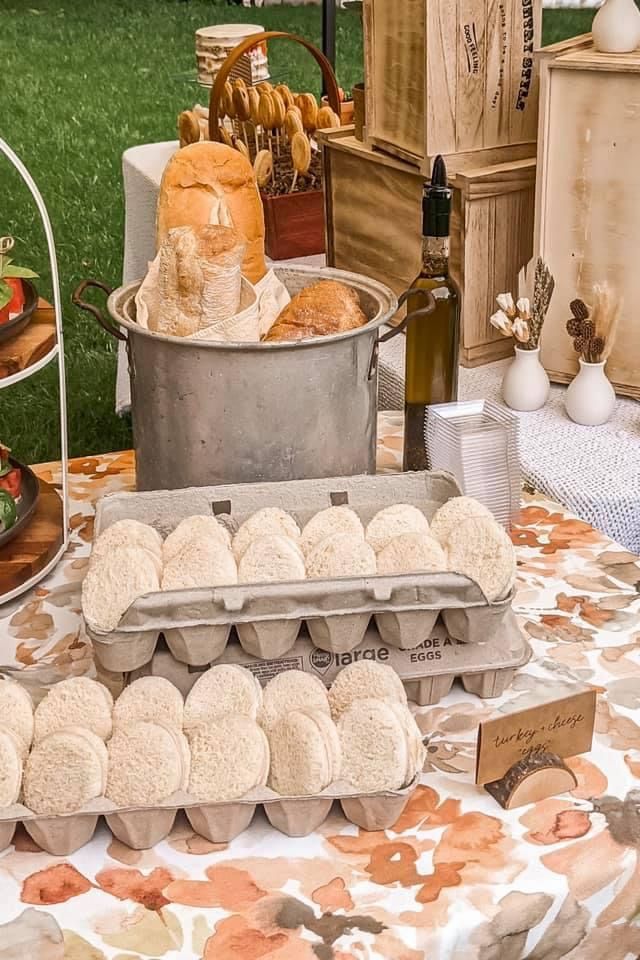 an assortment of pastries and breads on a table at a farmer's market