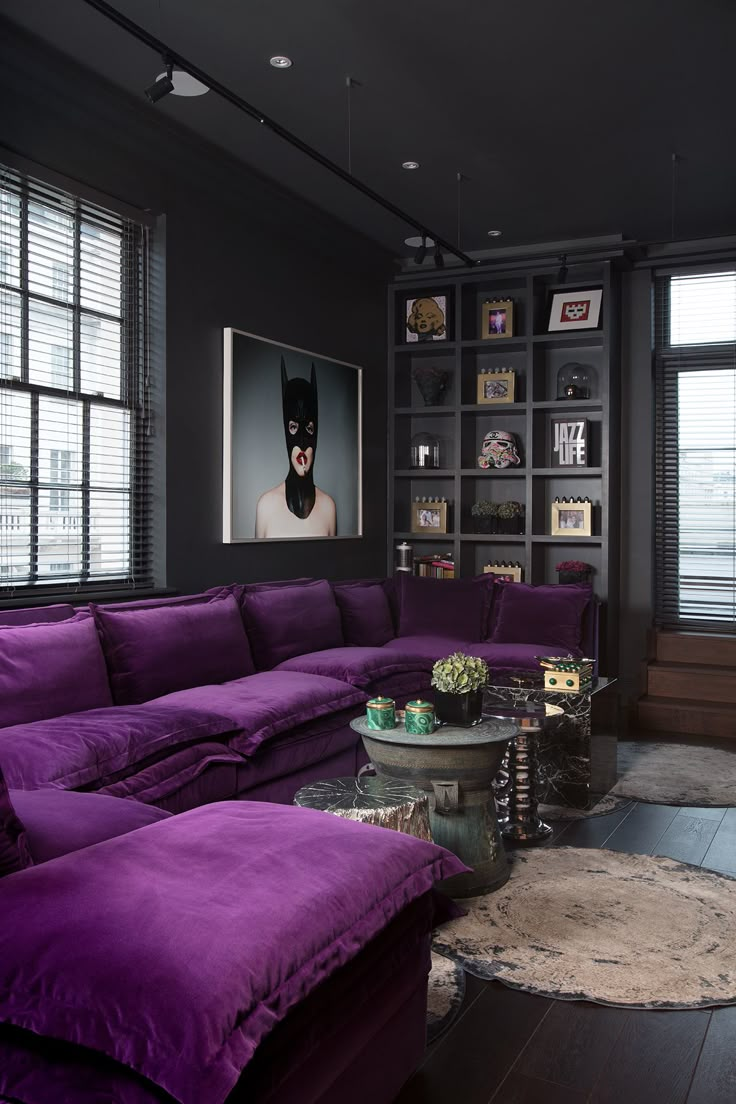 a living room filled with purple couches and bookshelves