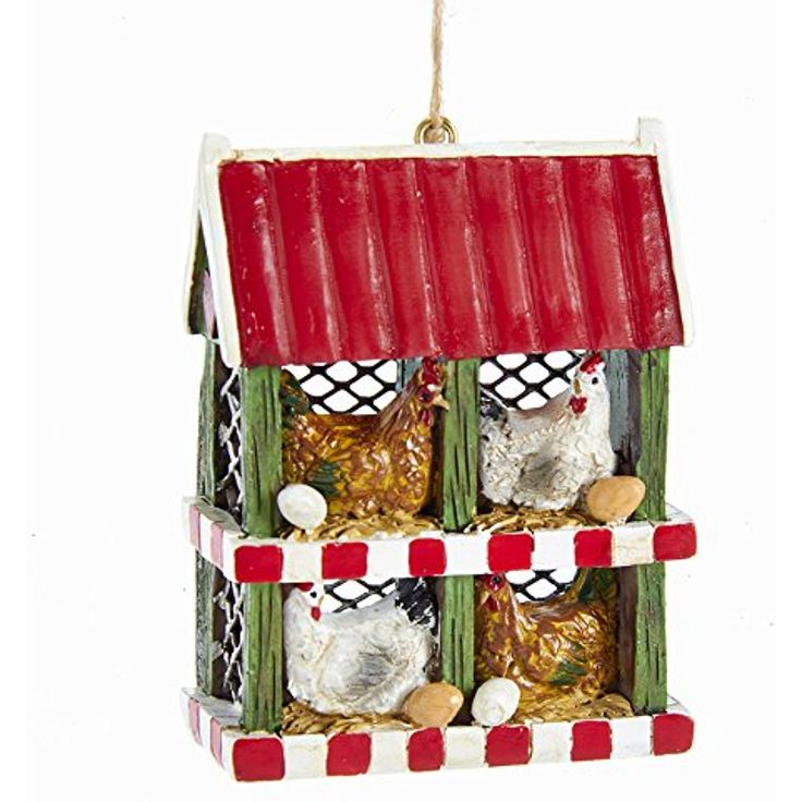 a christmas ornament hanging from a red and white house with chickens in it