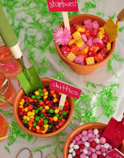 three bowls filled with candy sitting on top of a table next to other candies